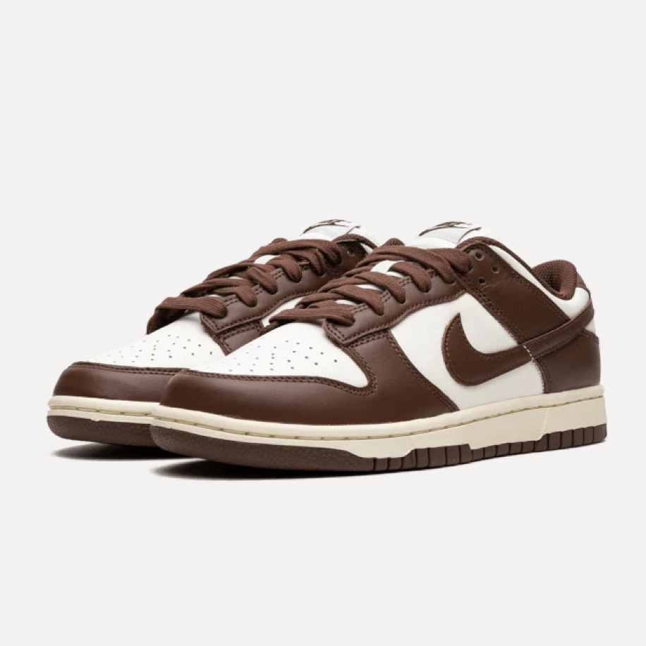 Para niskich sneakersów w brązowo-beżowej kolorystyce z jasnymi elementami na cholewce i podeszwie. Obuwie pokazano z boku na neutralnym tle, dzięki czemu widoczny jest kształt obu butów.